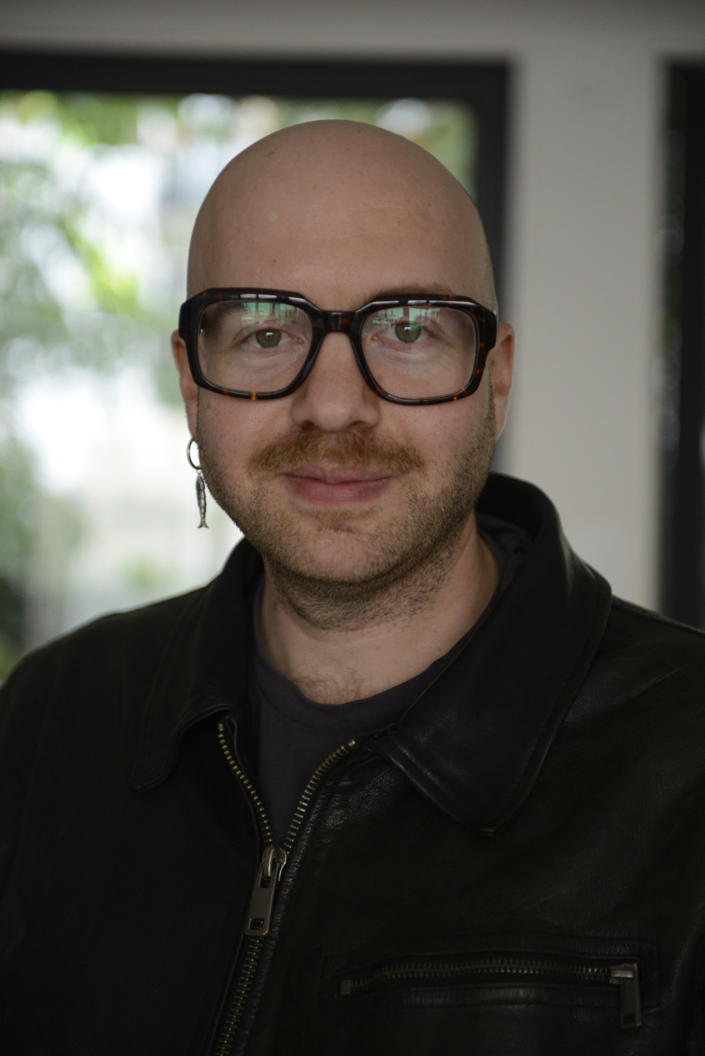 Aiden Vetter steht vor einem Fenster. Der Hintergrund ist verschwommen.