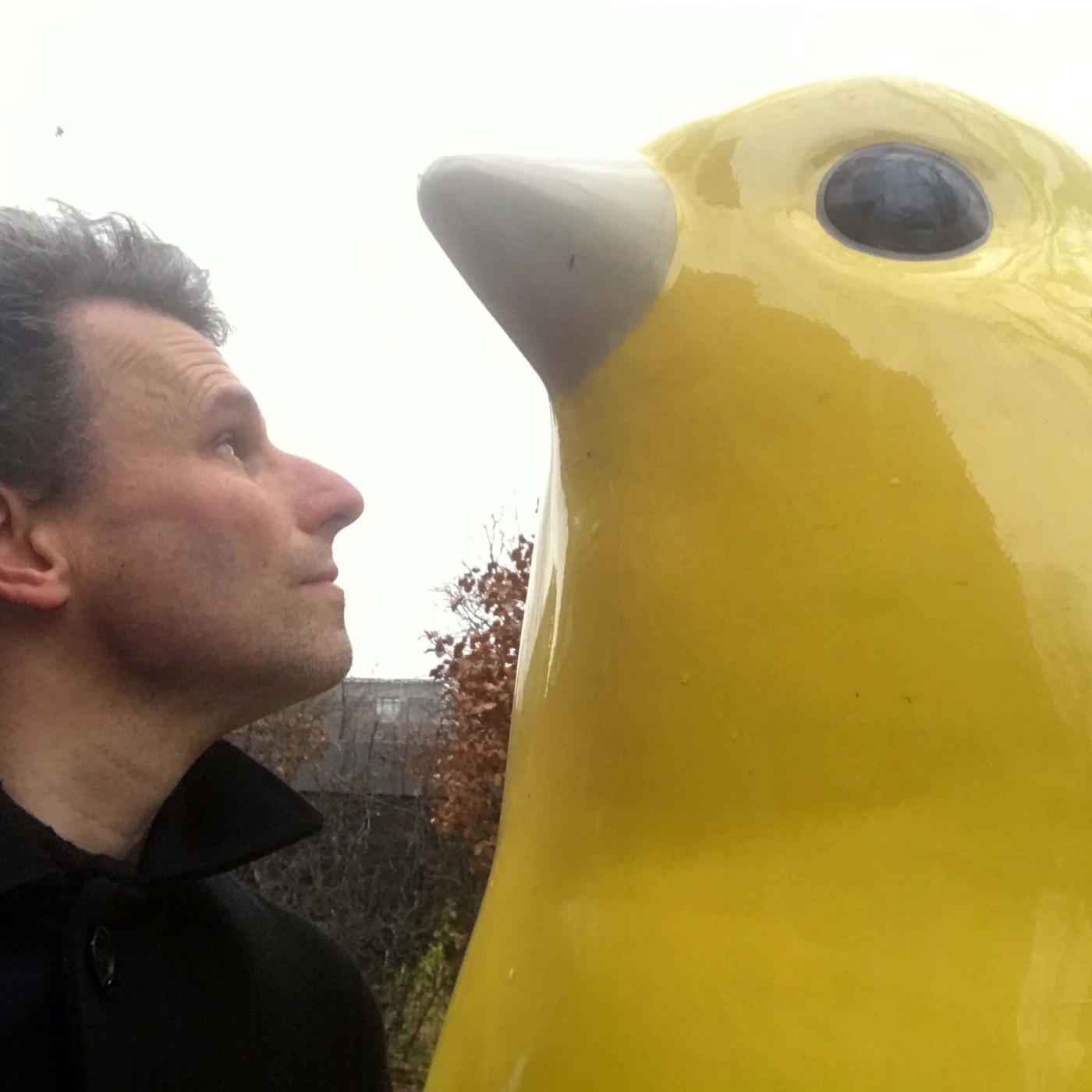 Georg Reinhardt mit einer großen Skulptur neben sich.
