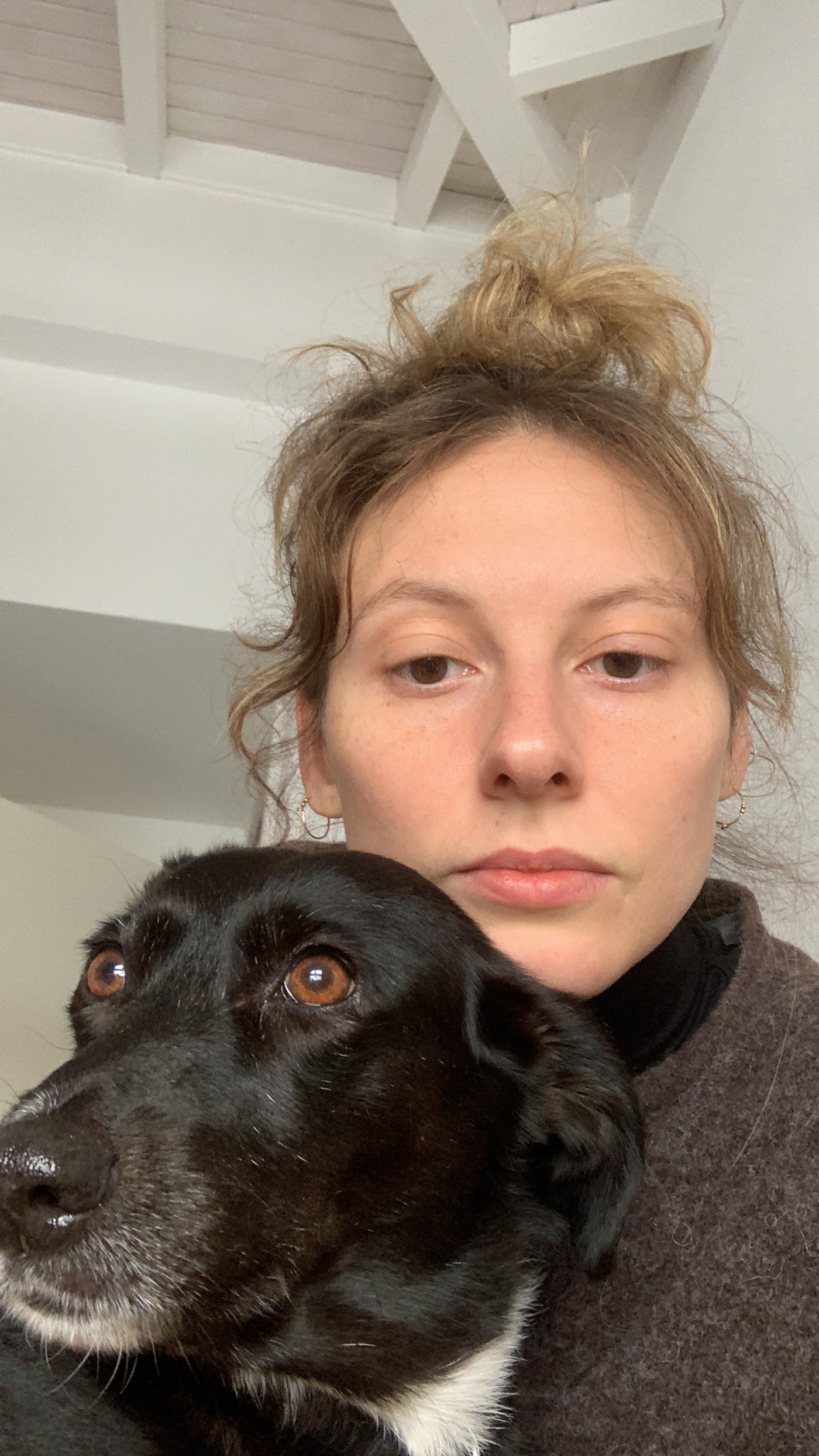 Laura Paloma schaut in die Kamera und hat einen Hund auf dem Schoß.