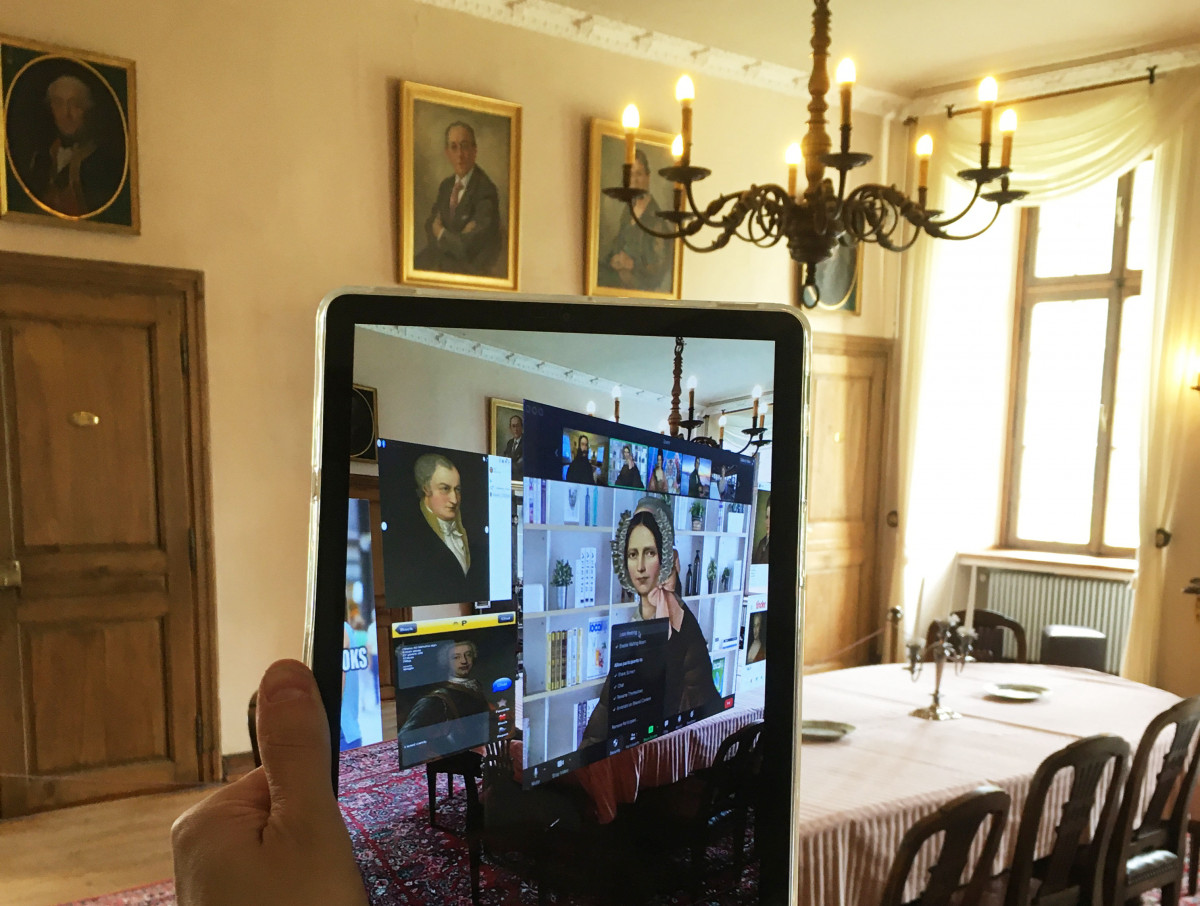 Im Museum hält eine Person ein Tablet in der Hand, auf dem mehr Informationen zu Annette von Droste zu Hülshoff per Augmentet Reality gezeigt werden.