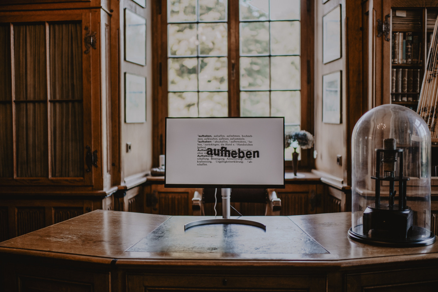 In der Bibliothek von Burg H&uuml;lshoff steht auf einem alten gro&szlig;en Schreibtisch ein Computerbildschirm. Auf dem Bildschirm ist ein Text abgebildet &uuml;ber dem in einer gr&ouml;&szlig;eren Schriftgr&ouml;&szlig;e das Wort &raquo;aufheben&laquo; steht. Dabei handelt es sich um die Installation &raquo;aufheben&laquo; von Michaela Mel&iacute;an, die sie im Rahmen des &raquo;Westopia&laquo; - Festivals pr&auml;sentiert.