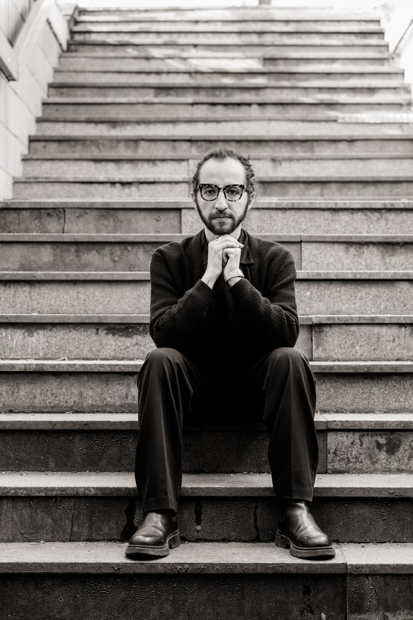 Portrait von Abdalrahman Alqalaq, sitzend auf einer Treppe. Das Foto ist schwarz-weiß. Copyright: Jan Hillnhütter