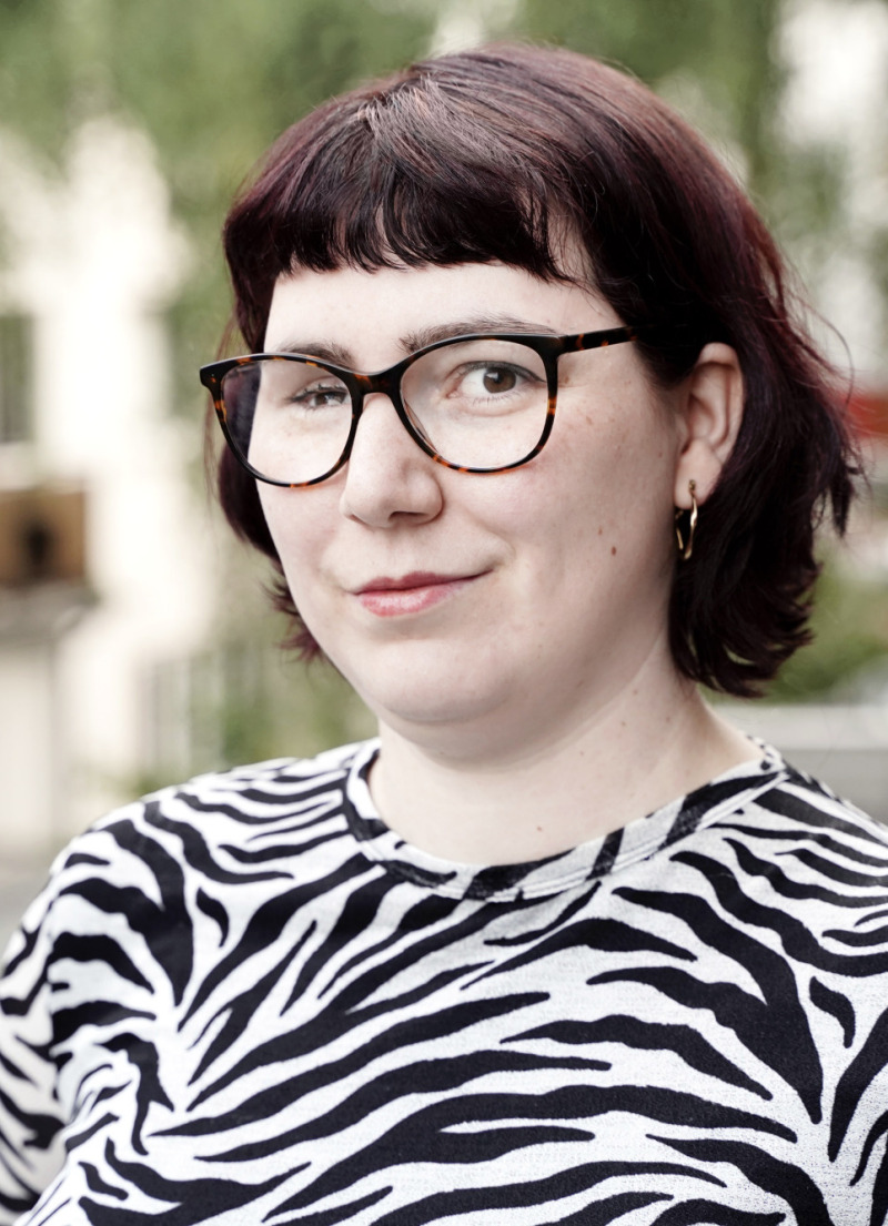 Laura S. Hennig vor einer Straße mit Häusern.