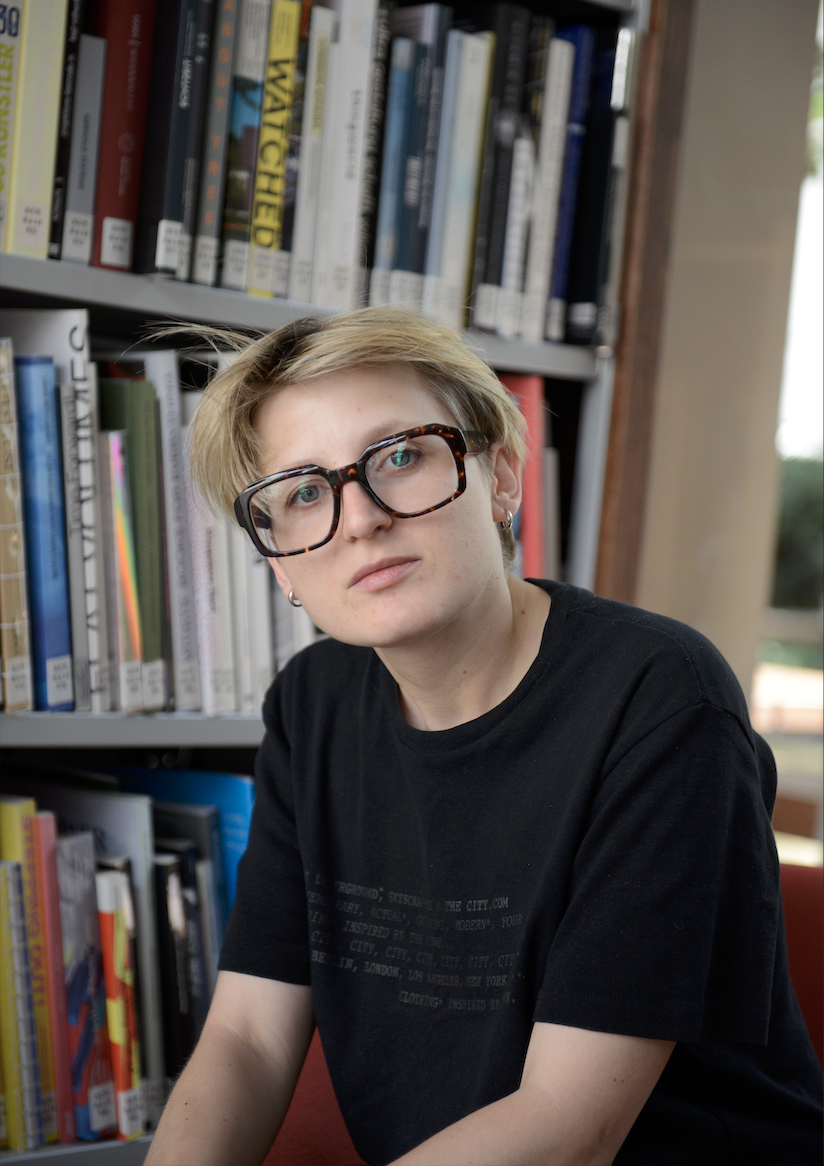 Polina Korovina vor einem Bücherregal.
