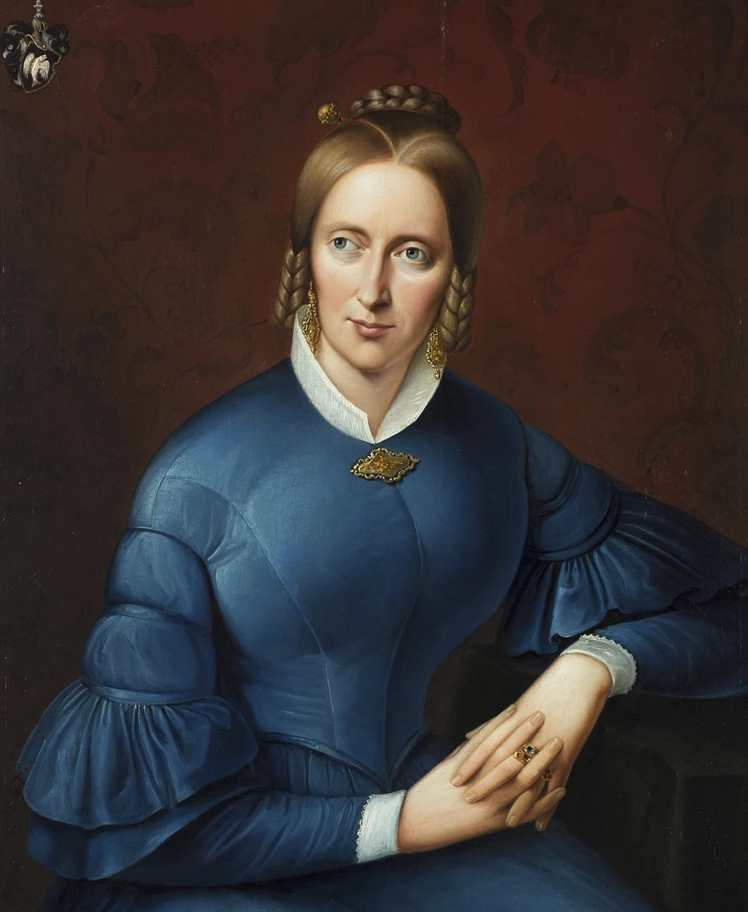 Droste sitzend und mit ihrem linken Arm erh&ouml;ht abgelegt. Ihre H&auml;nde sind locker ineinander verschr&auml;nkt. Droste tr&auml;gt ein blaues Kleid mit einem wei&szlig;en Stehkragen und Brosche. Drostes Haar ist, f&uuml;r die Zeit des Biedermeier typisch, geflochten und am Hinterkopf hochgesteckt. Der vordere Teil des Haars ist an den Schl&auml;fen gelockt. Droste blickt selbstbewusst nach rechts aus dem Bildraum heraus. Oben links in der Ecke ist das Droste-Wappen abgebildet.