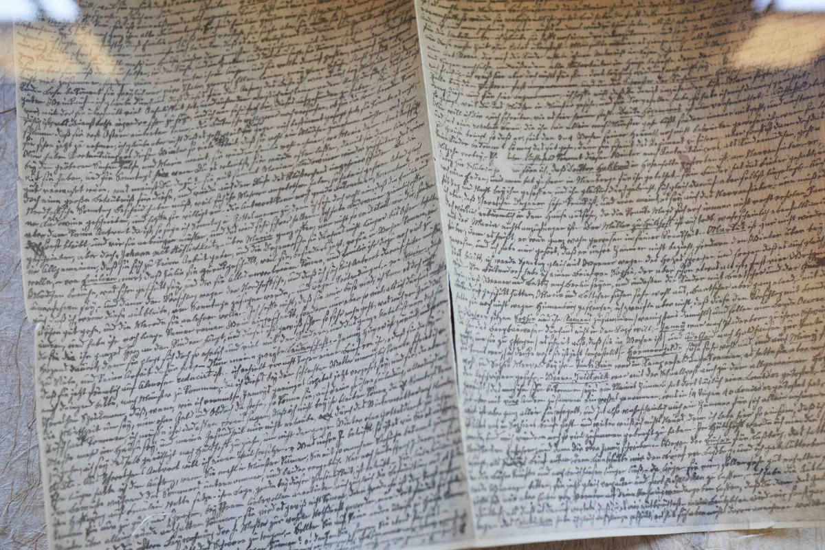 Handschrift von Droste hinter Glas. Aufgefaltetes Blatt. Die Handschrift f&uuml;llt millimeterklein in Reihen das gesamte Blatt.
