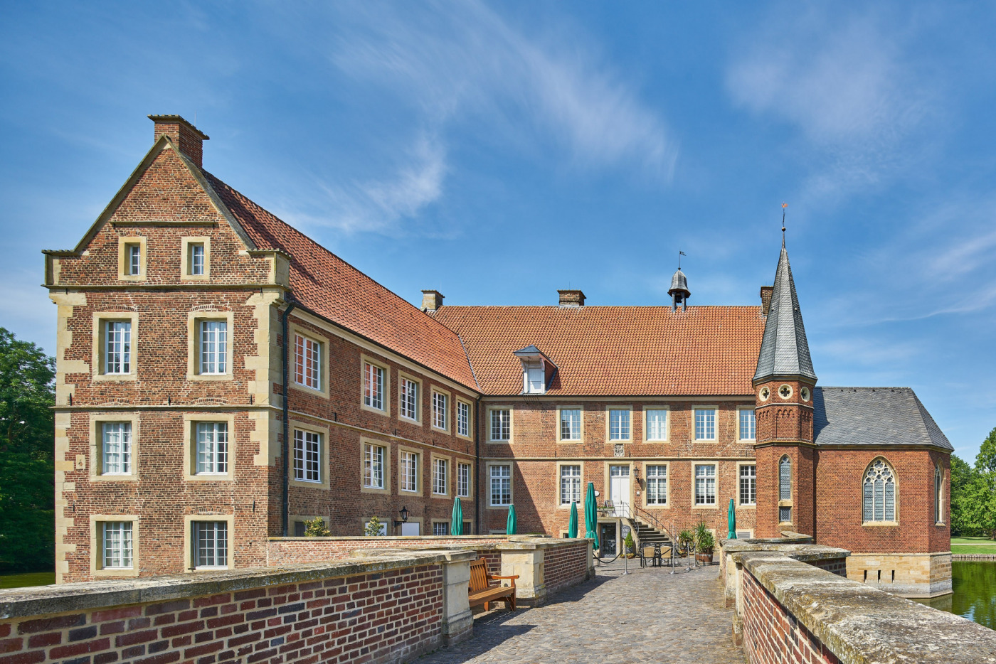 Burg H&uuml;lshoff bei blauem Himmel. Foto aufgenommen auf der Br&uuml;cke, die vom Burghof &uuml;ber die Gr&auml;fte zum Burggeb&auml;ude f&uuml;hrt.